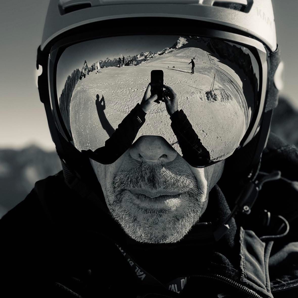 Alessandro Schiasselloni sulla neve, con il paesaggio alpino riflesso nella maschera